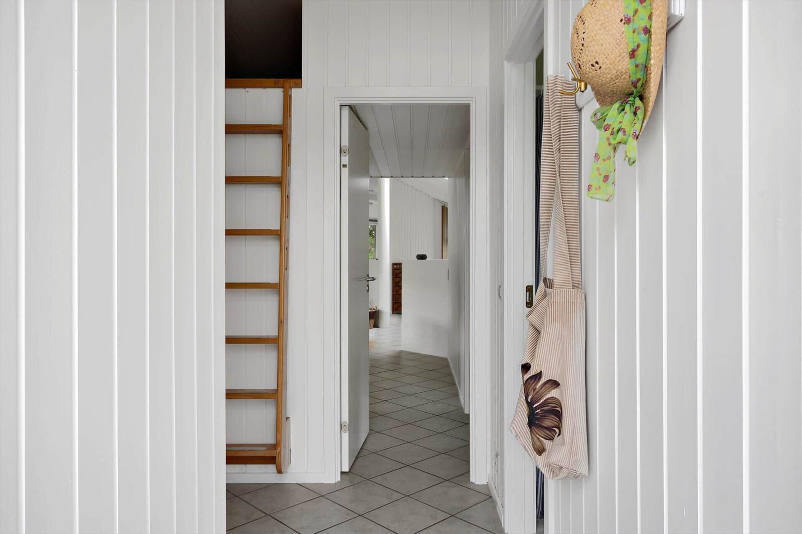 Hallway with wooden ladder and hanging items