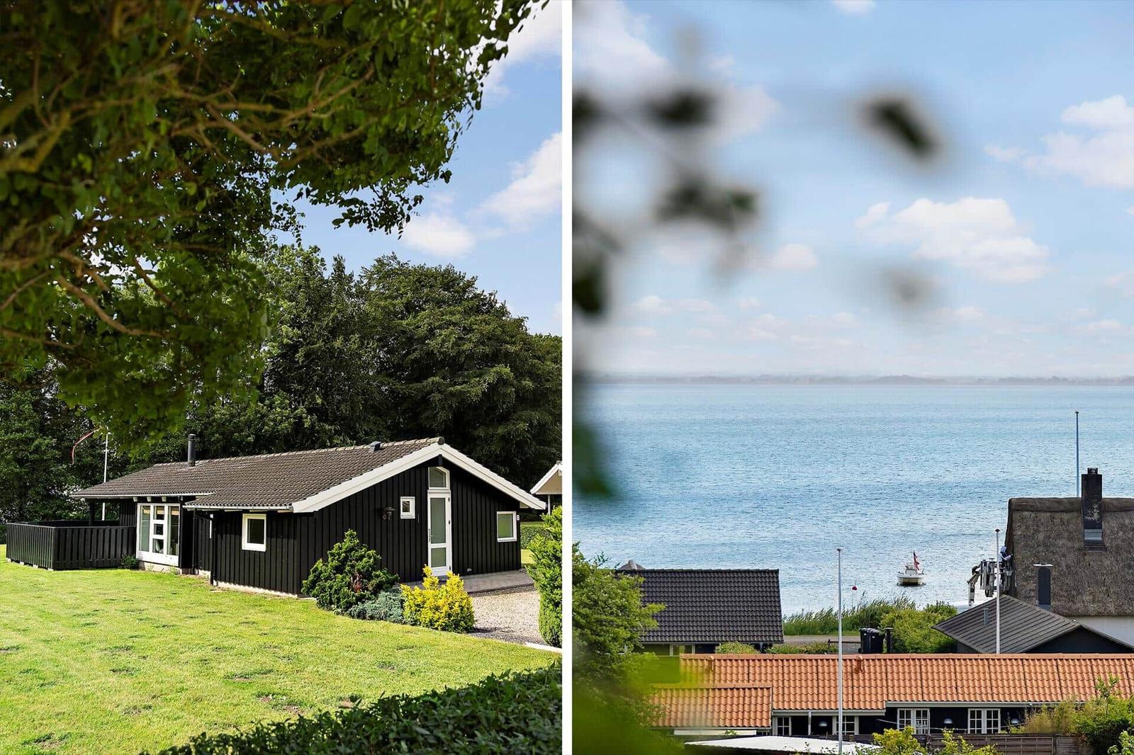 Black house with green lawn. View of the sea with boats.