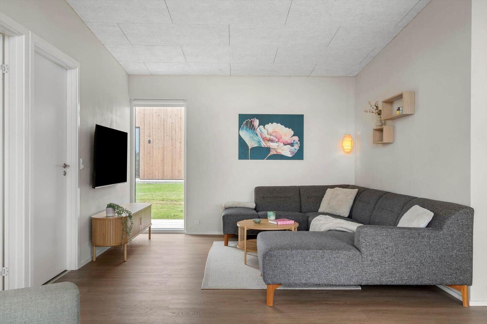 Wohnzimmer mit grauem Sofa, Holzboden und Wandbild