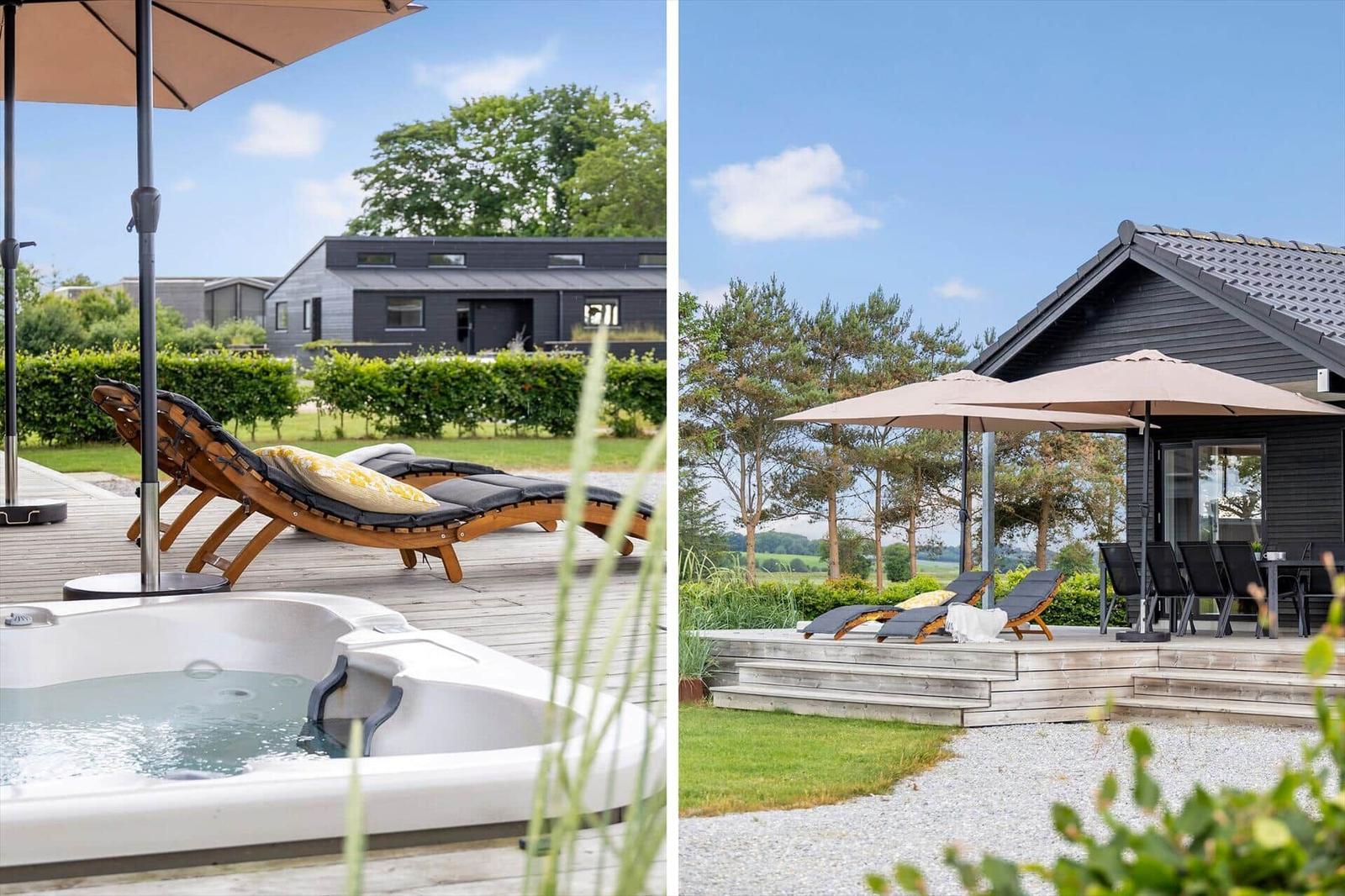 Outdoor area with hot tub, sun loungers, and terrace in front of modern wooden house.