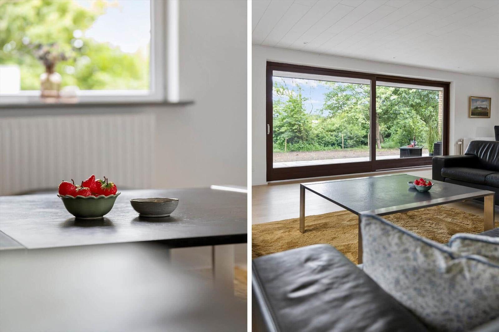 Living room with large window, sofa, and table with strawberries.