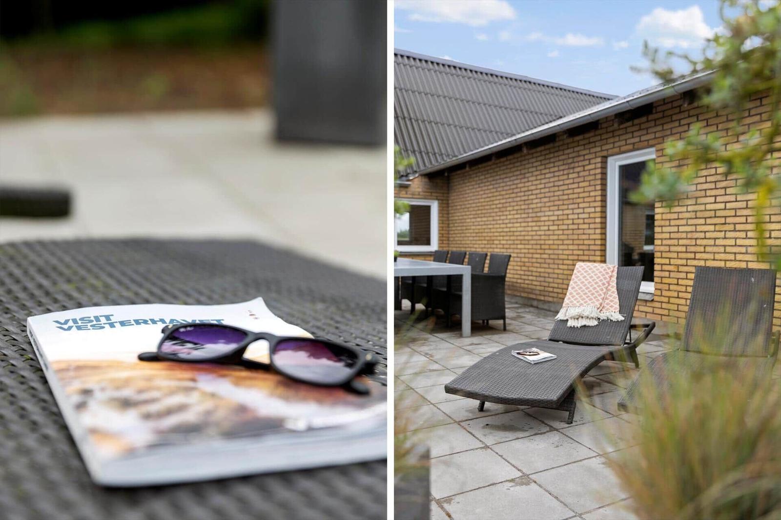 Outdoor area with lounge chairs and table. Brochure and sunglasses on table top.