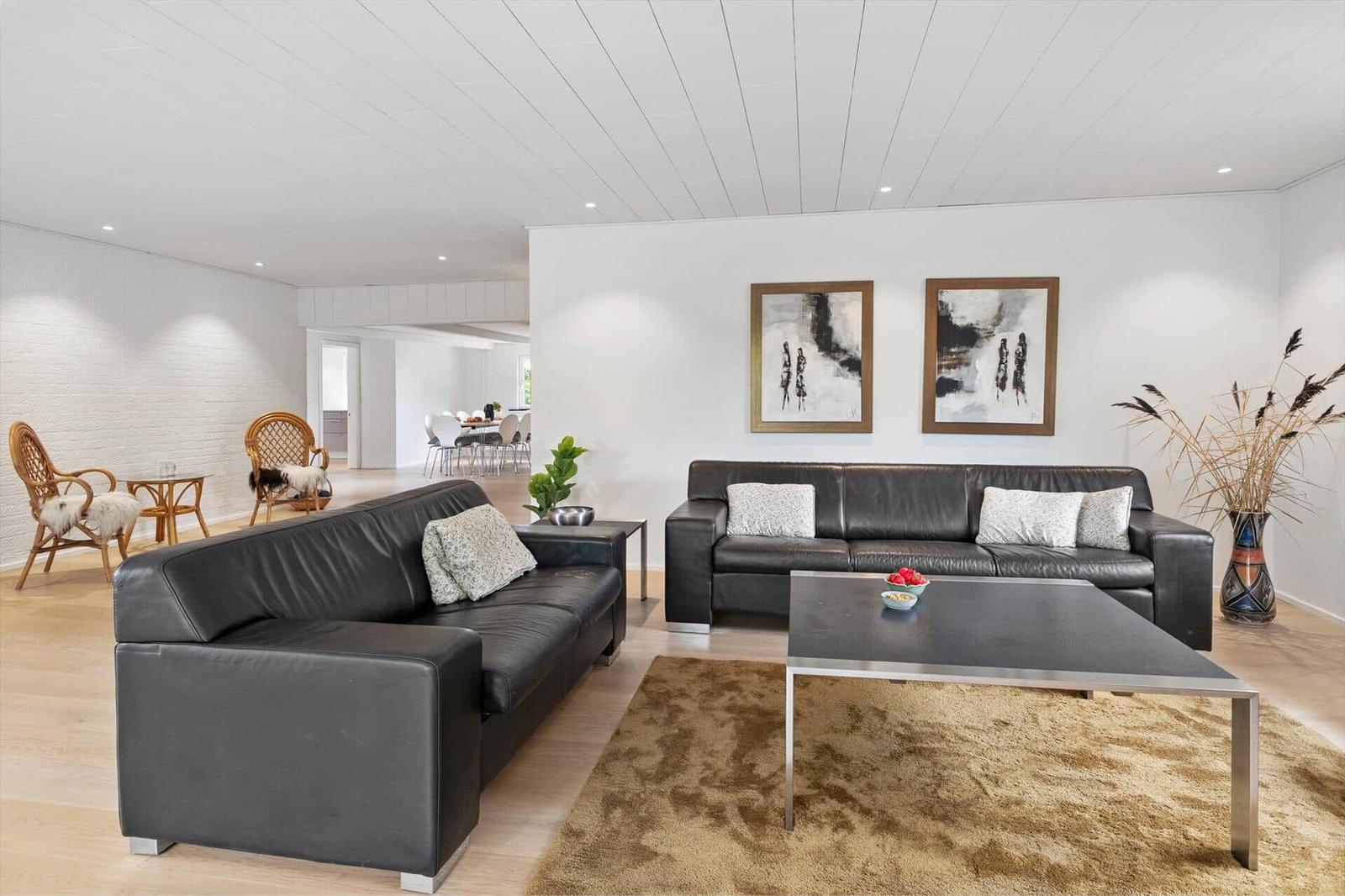 Two black leather sofas, a table, and wall art in the living room.