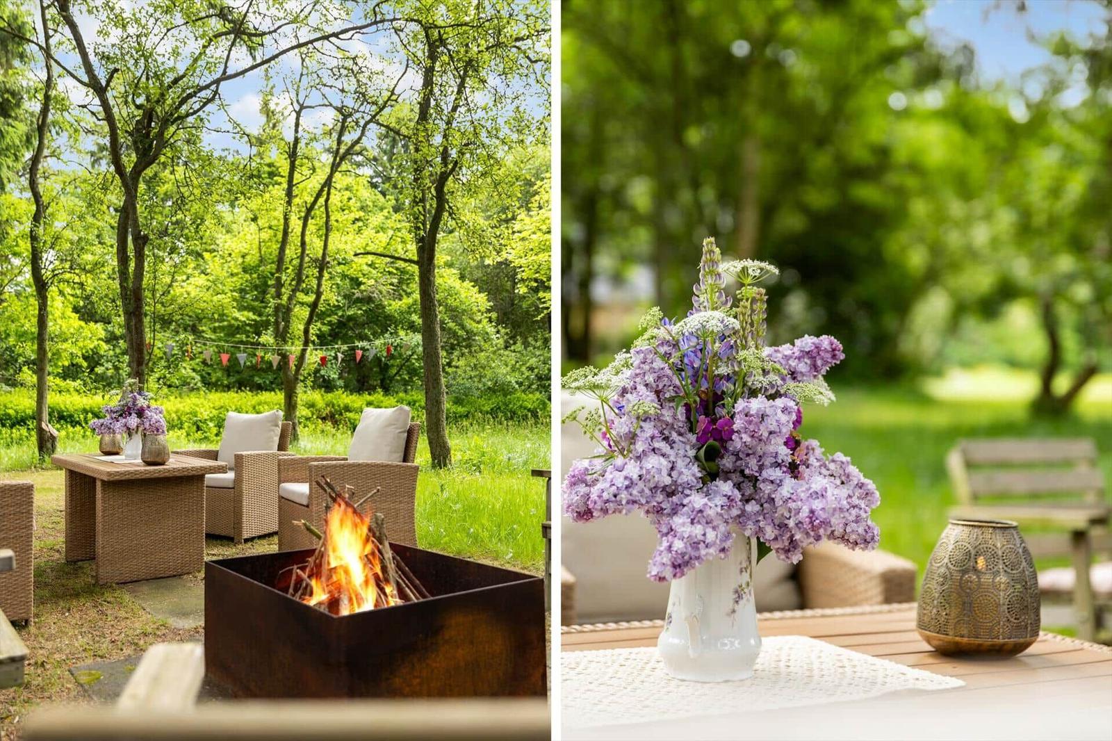 Außenbereich mit Feuerkorb, Sitzgruppe und Blumenarrangement.