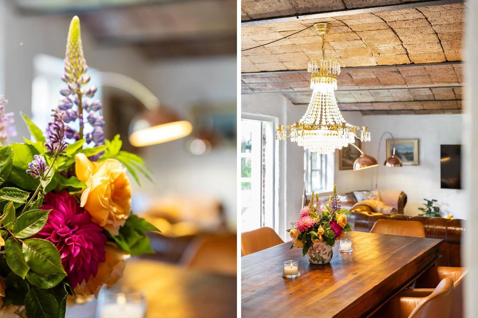 Ein Esszimmer mit Holztisch, Kronleuchter und Blumenvase.