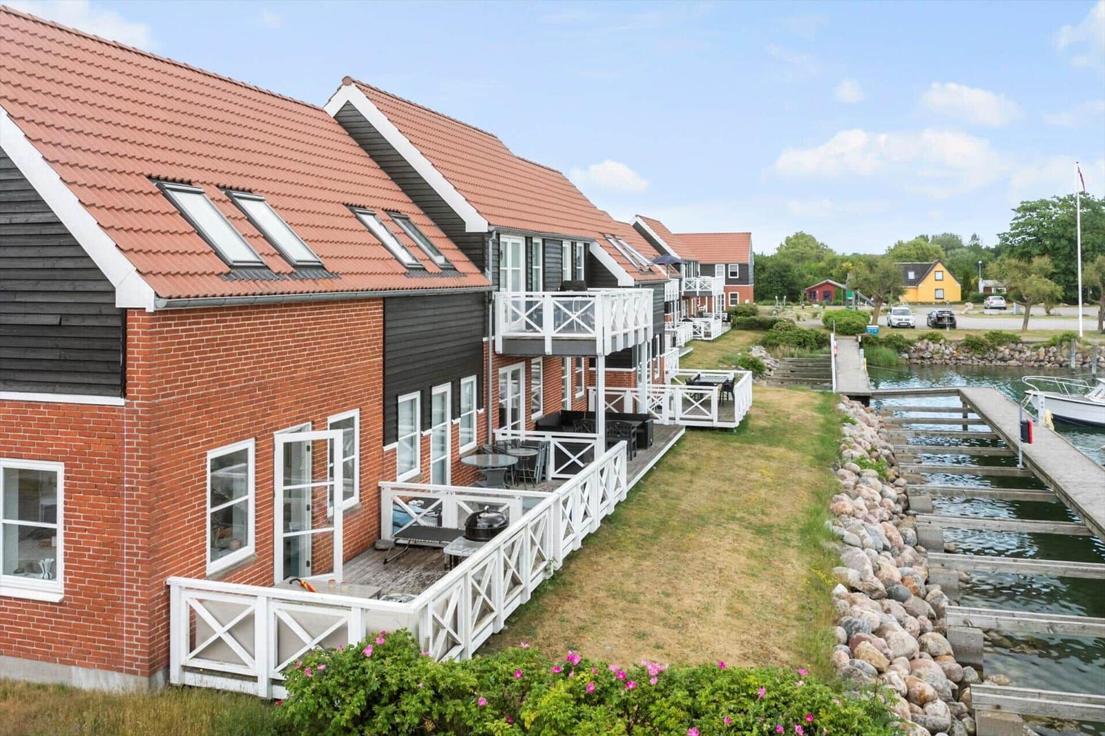 Reihenhäuser mit Terrassen und Blick auf Wasser.