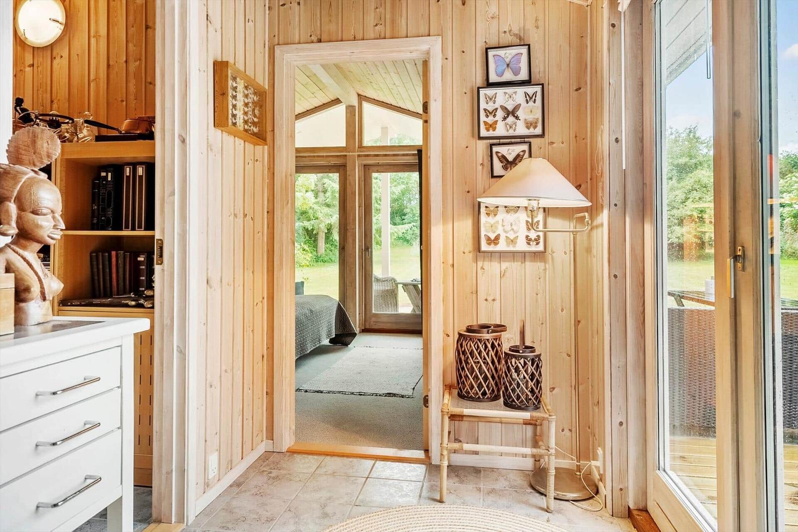Holzvertäfelte Türöffnung mit Blick in Schlafzimmer und Terrasse