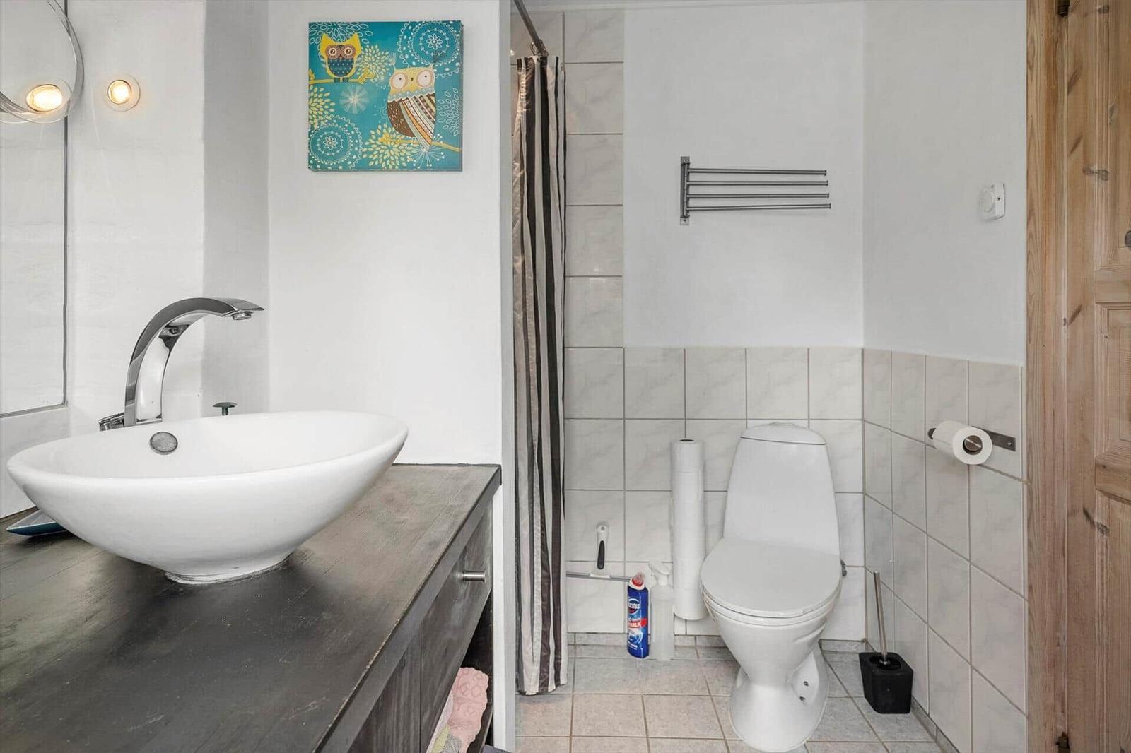 Badezimmer mit Waschbecken, Toilette und Dusche.