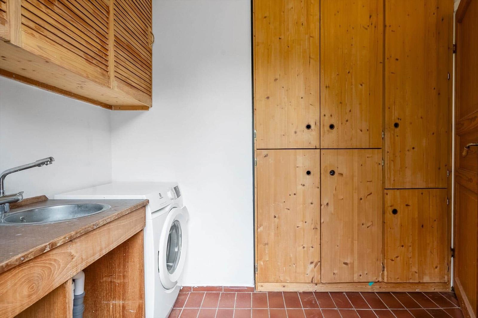 Wohnung mit Waschmaschine, Spüle und Holzschränken