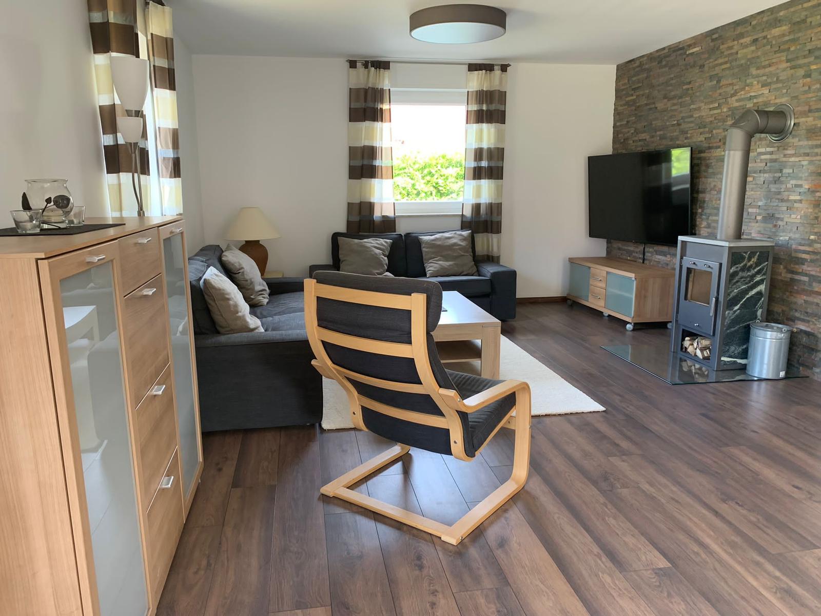 Wohnbereich mit Sofa, Kamin und TV.