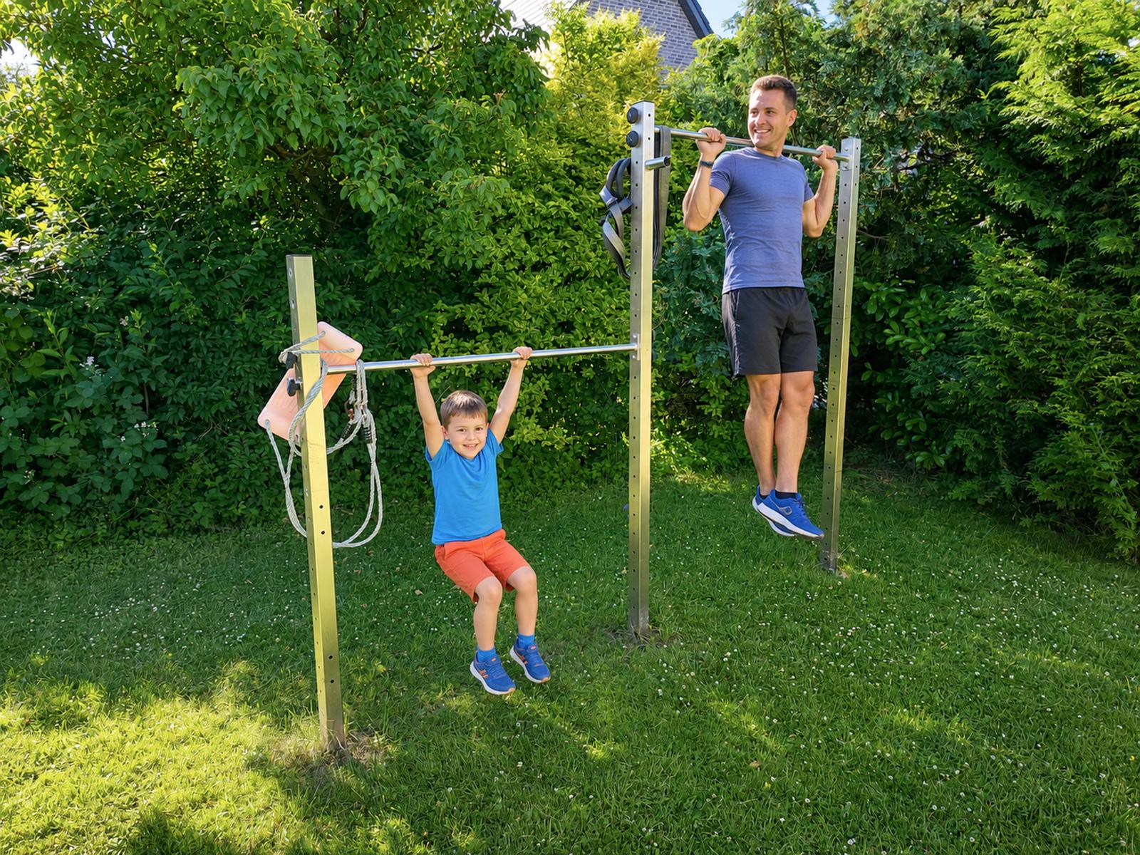 Ein Mann und ein Junge trainieren auf einem Außenklettergerüst im Garten.