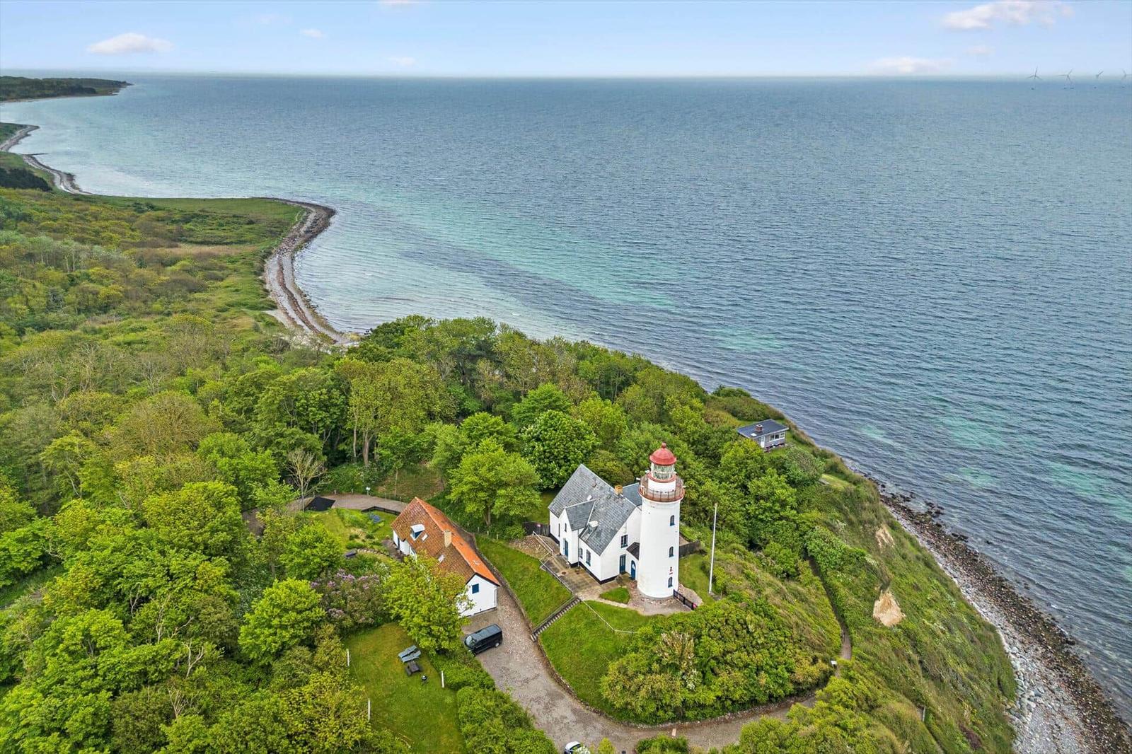 Lichtturm und Haus auf grüner Halbinsel am Meer