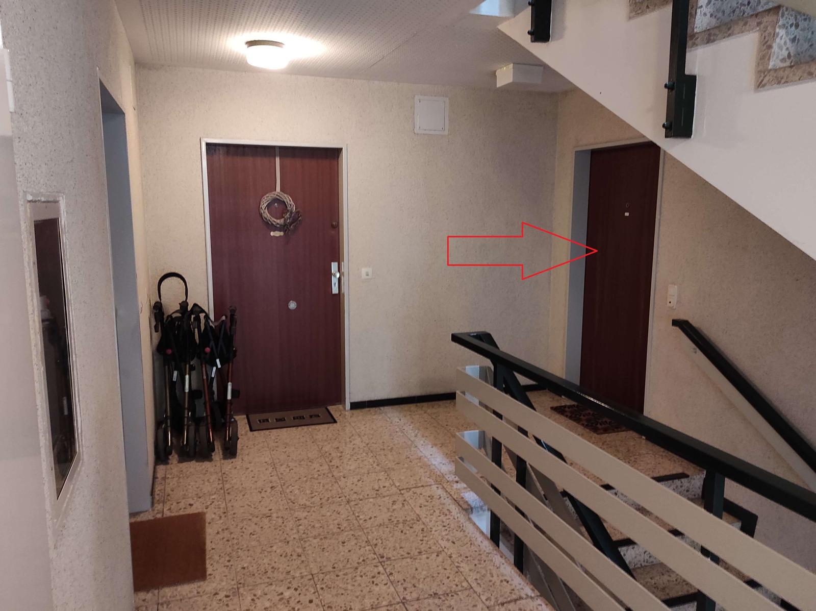 Flur mit Tür, Rollstühlen und Treppenhaus