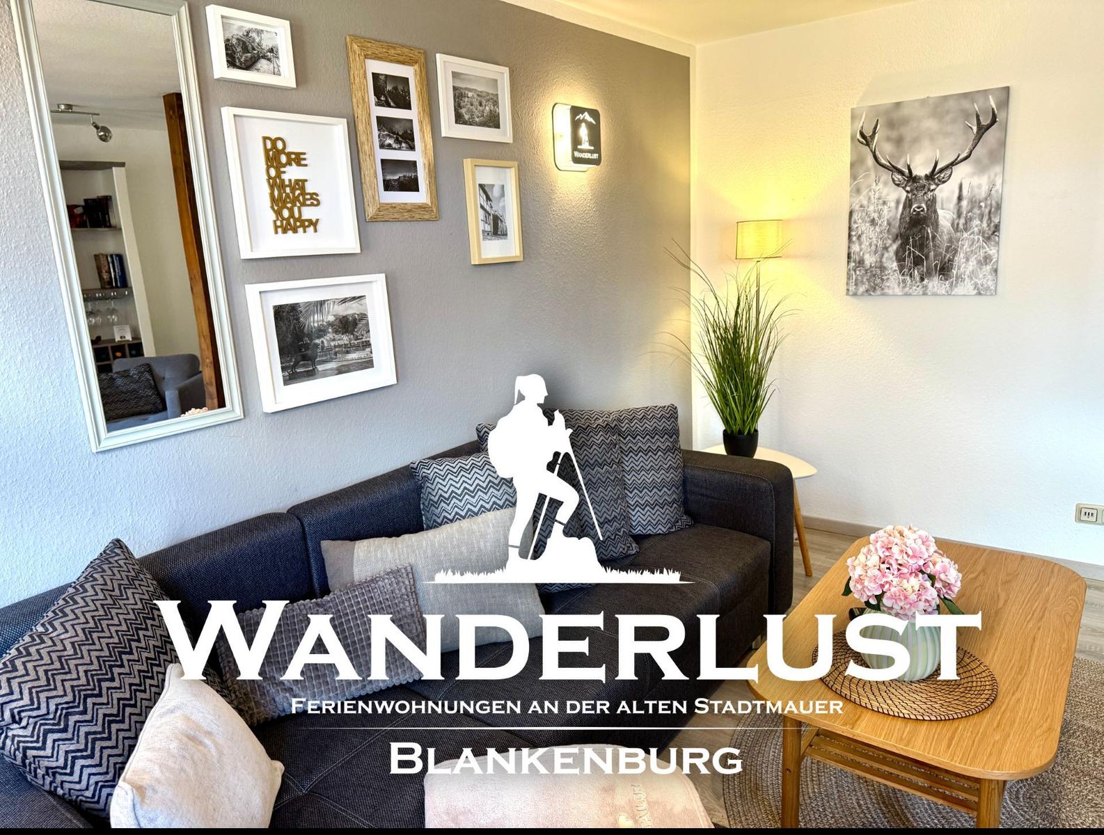 Wohnzimmer mit Sofa, Tisch und Wanddekoration an der alten Stadtmauer in Blankenburg.