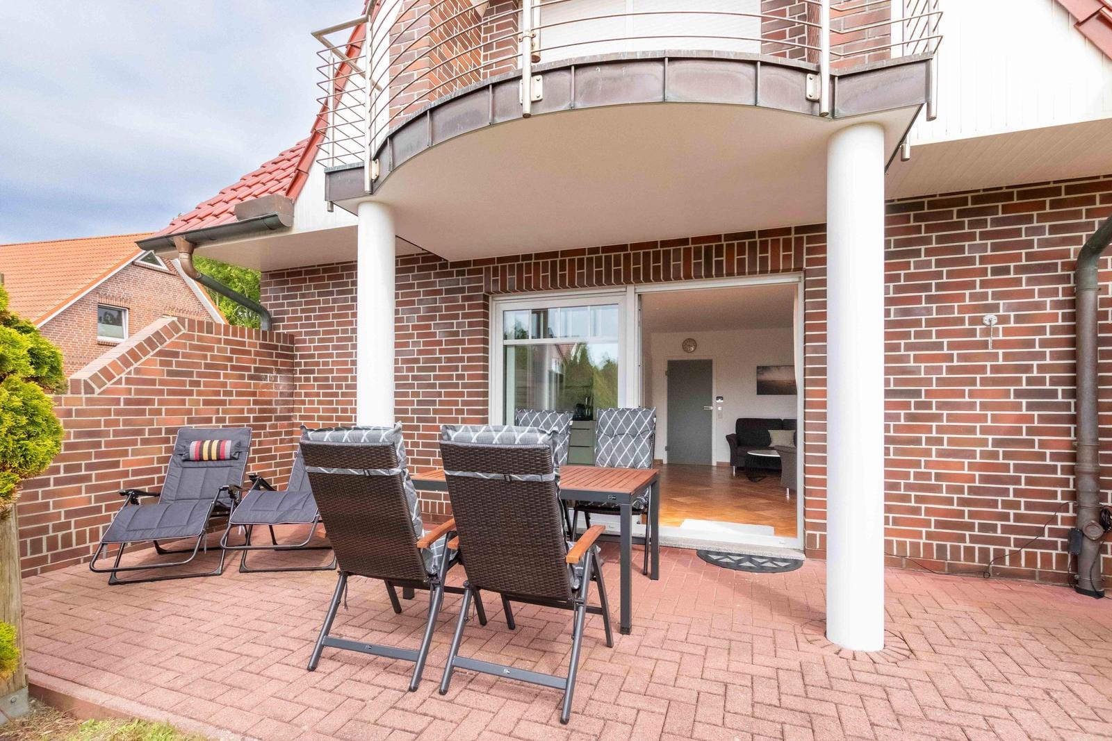 Terrace with seating group and view into the house. Red brick patio with balcony.