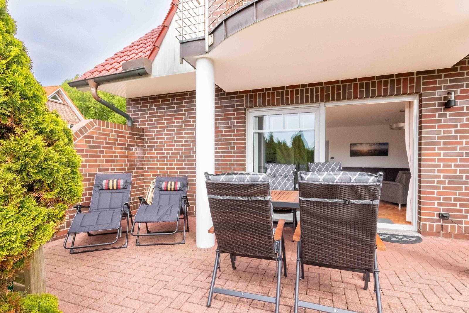 Terrace with seating group and sun loungers. Entrance to living room.