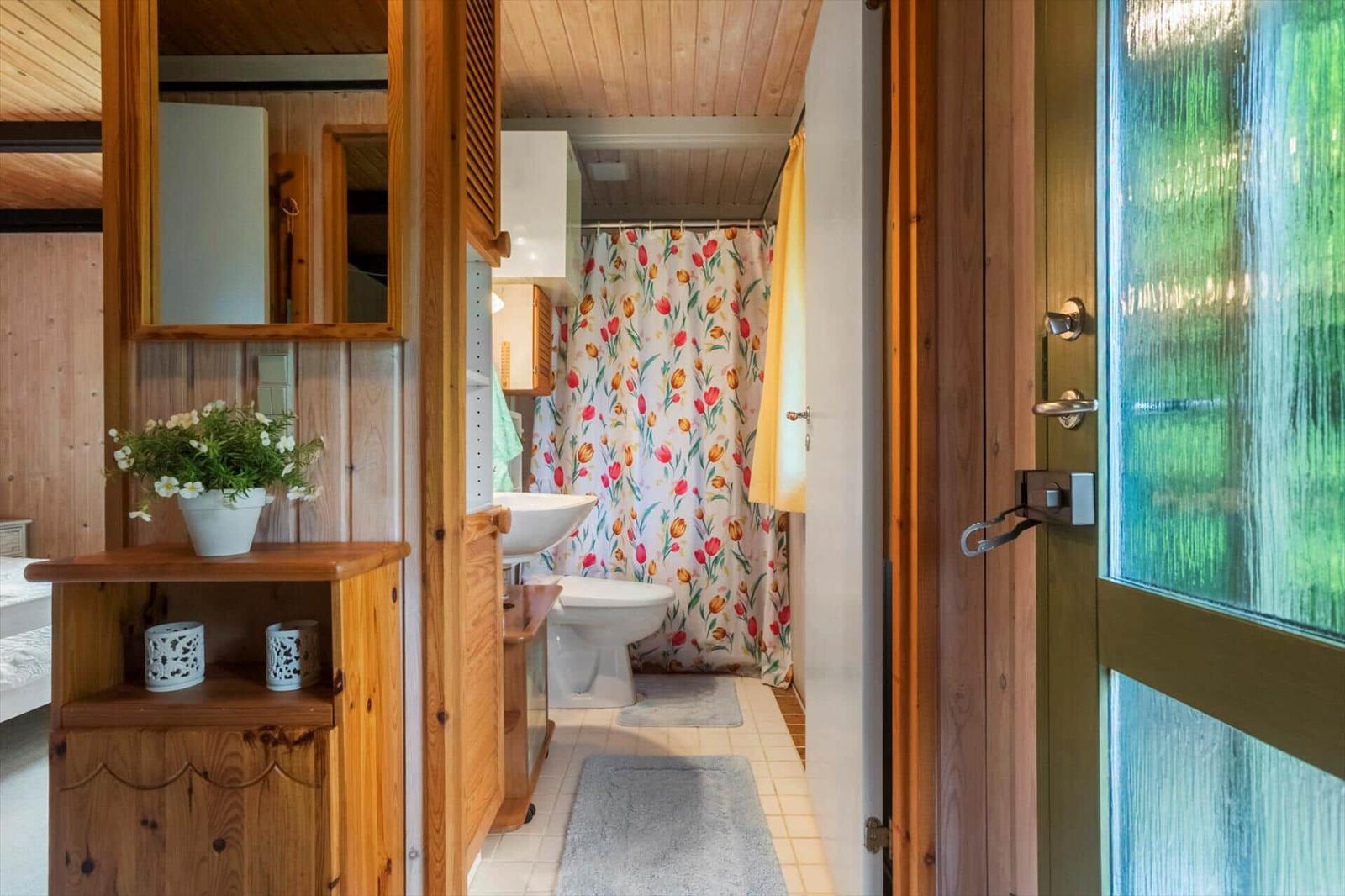 Badezimmer mit Holzwand, Tulpen-Duschvorhang und Waschbecken