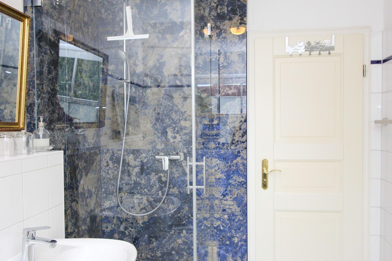 Bad mit Dusche, blauem Marmor und weißem Waschtisch