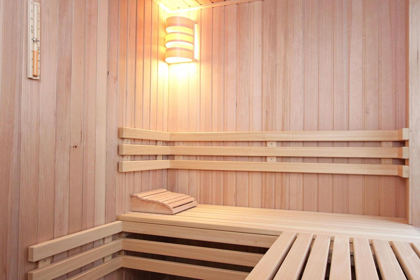 Holzsauna mit Sitzbänken und Wandthermometer