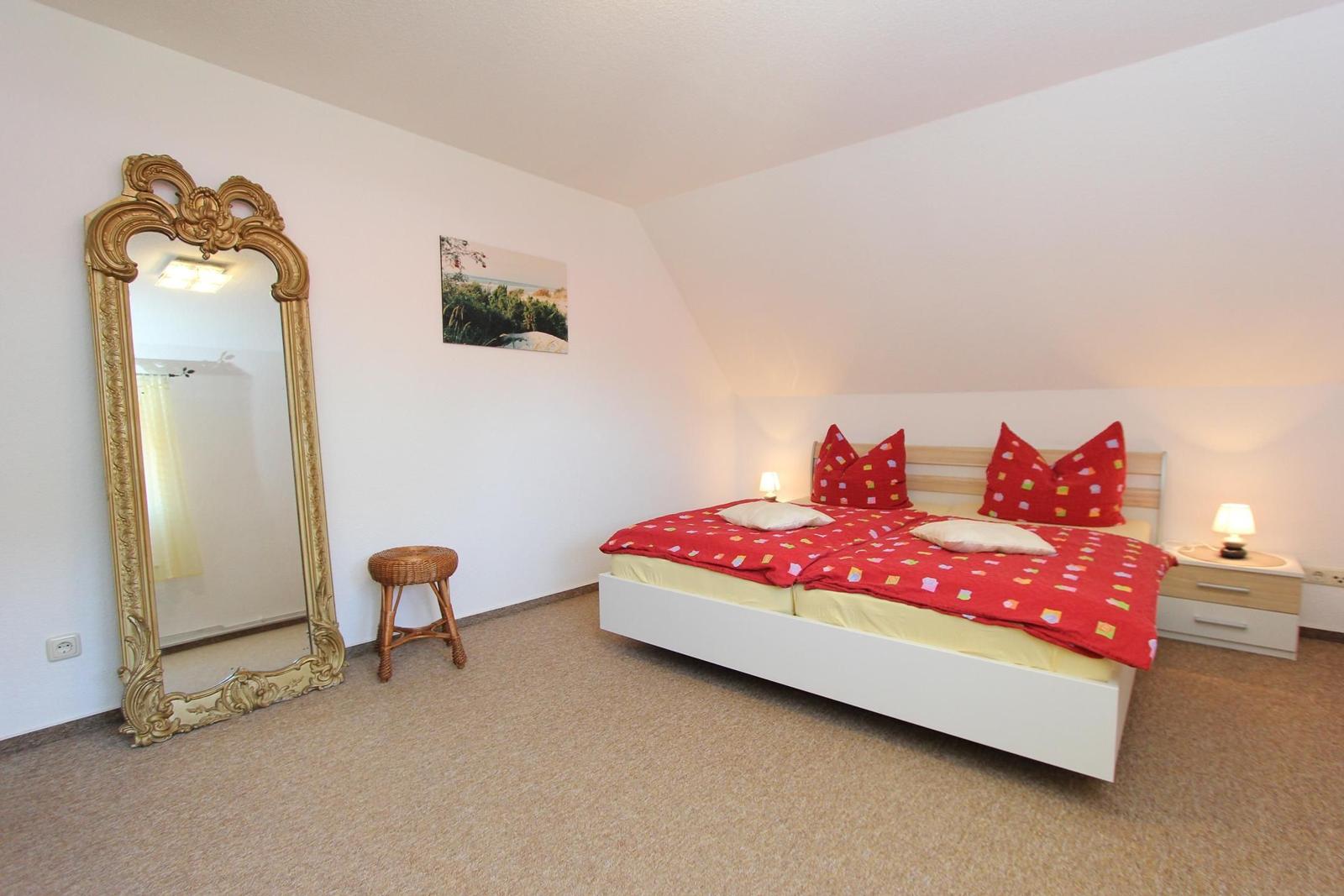 Schlafzimmer mit Doppelbett, Spiegel und Nachttisch