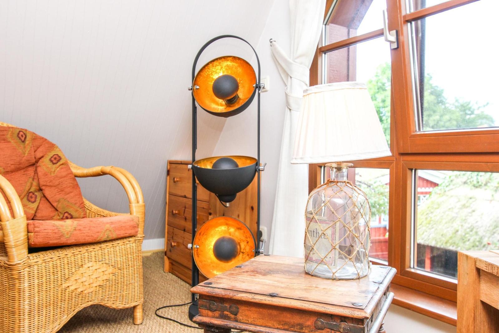 Wohnzimmer mit Stuhl, Tisch, Lampe und Fenster