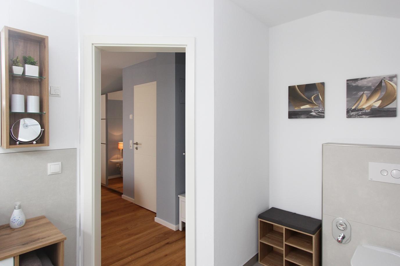Flur mit Holzboden, Wandregal und Bildern an der Wand