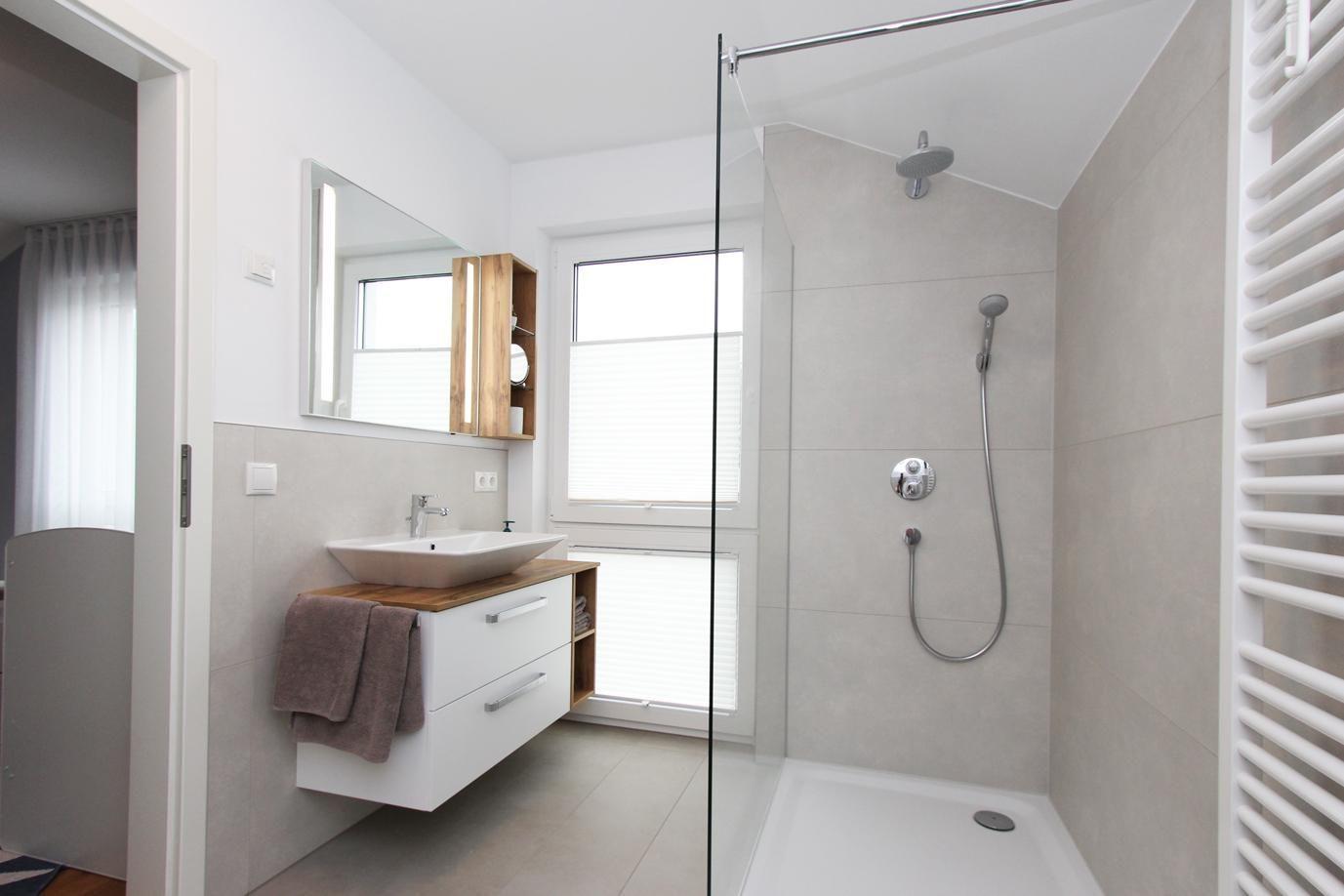 Badezimmer mit Dusche, Waschbecken und Spiegel