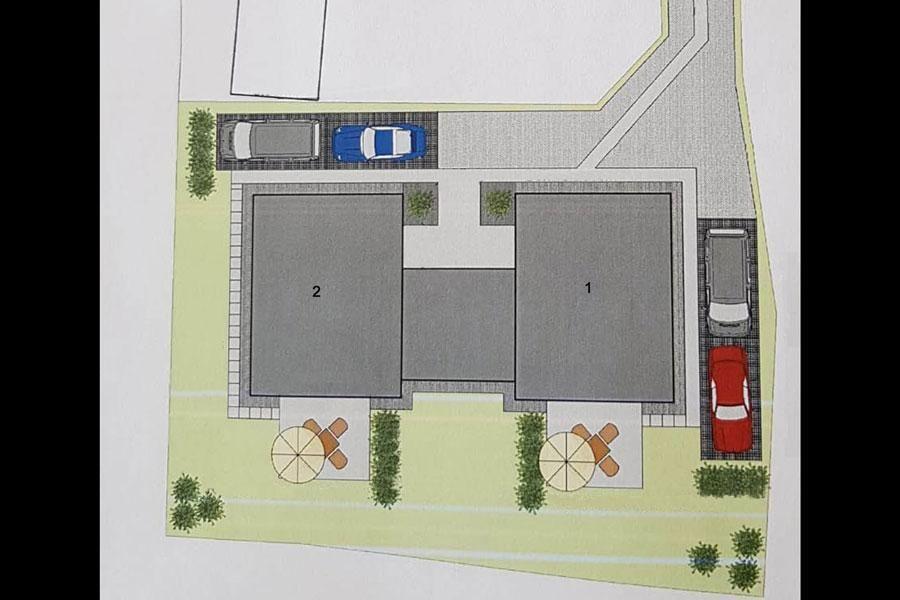 Plan zeigt zwei Gebäude mit Parkplätzen und zwei Gartenbereichen mit Sonnenschirmen.