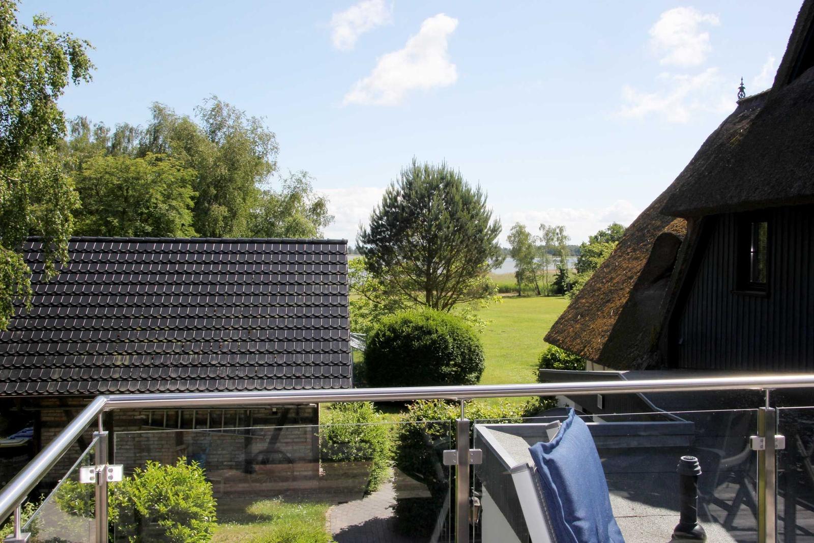 Terrasse mit Blick auf grünen Garten und traditionelle Häuser mit Dach