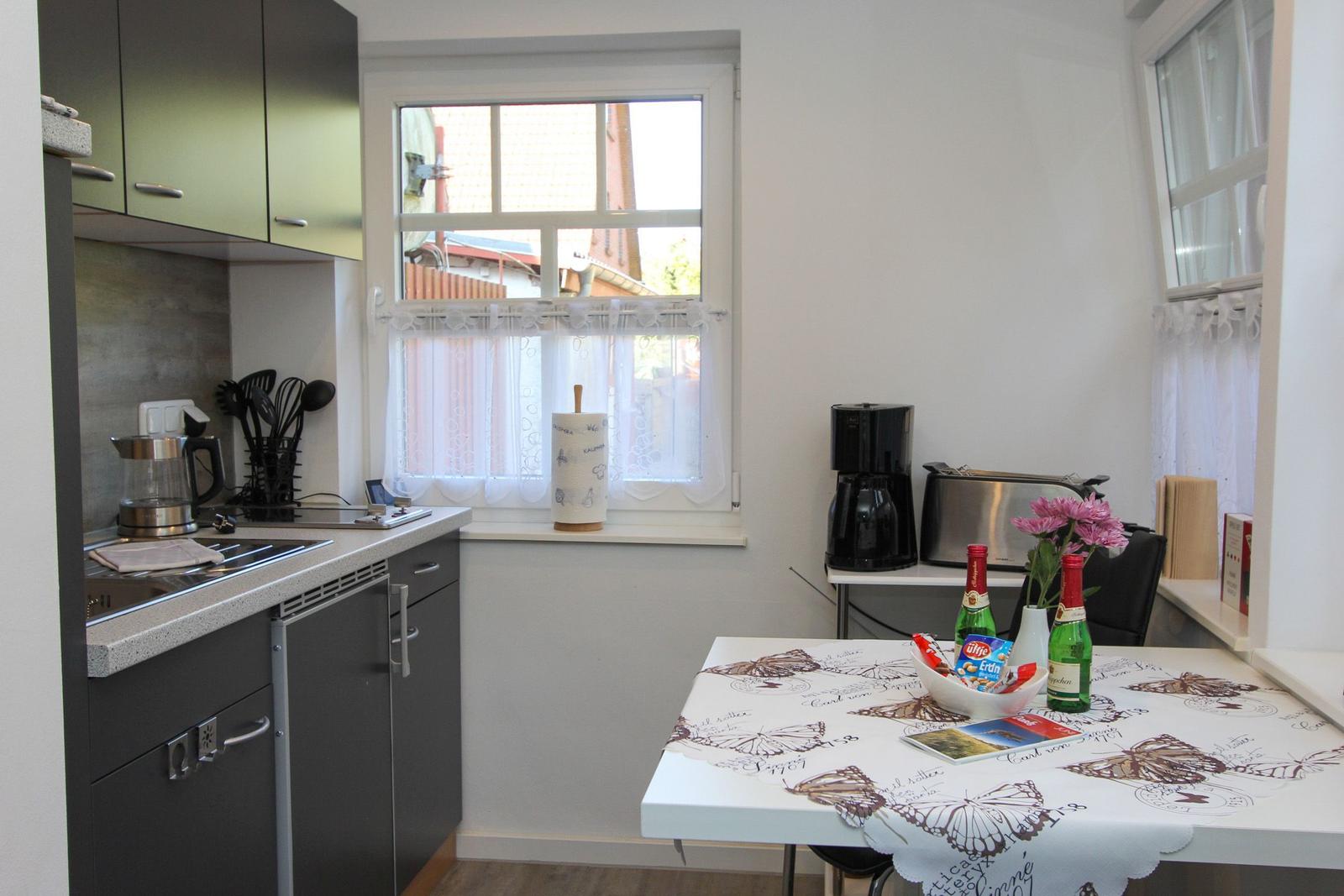 Küche mit Tisch, Fenster und Küchengeräten.