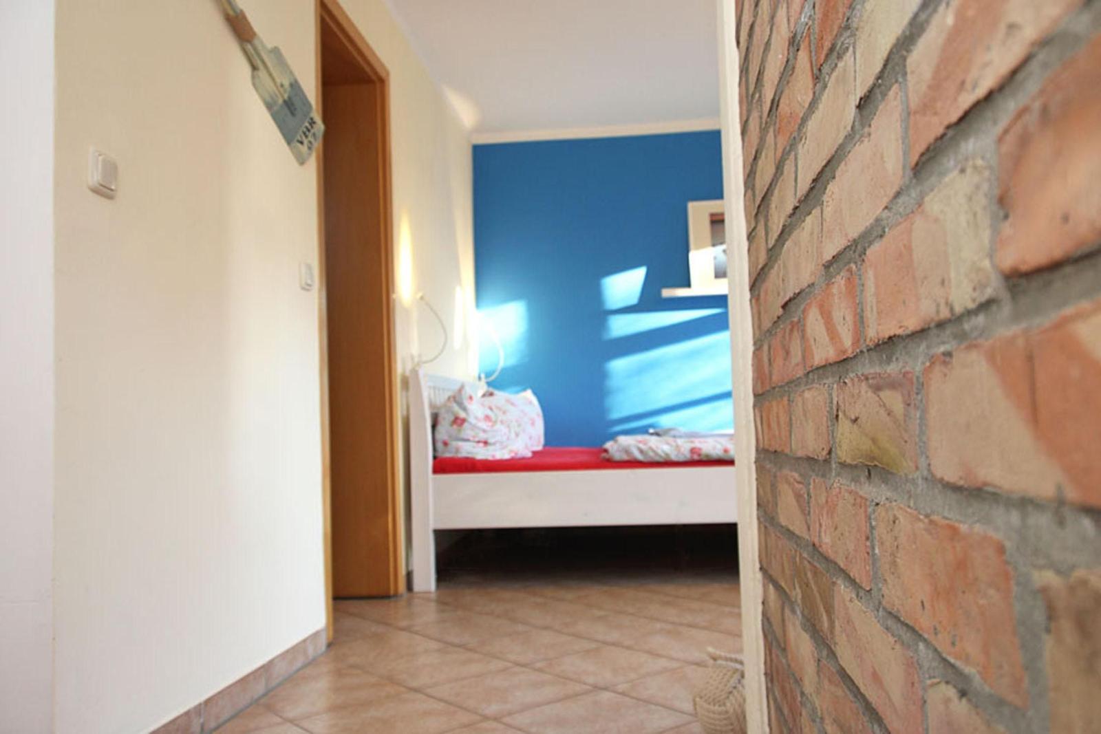 Ein Raum mit einem Bett, blauer Wand und Backsteinwand