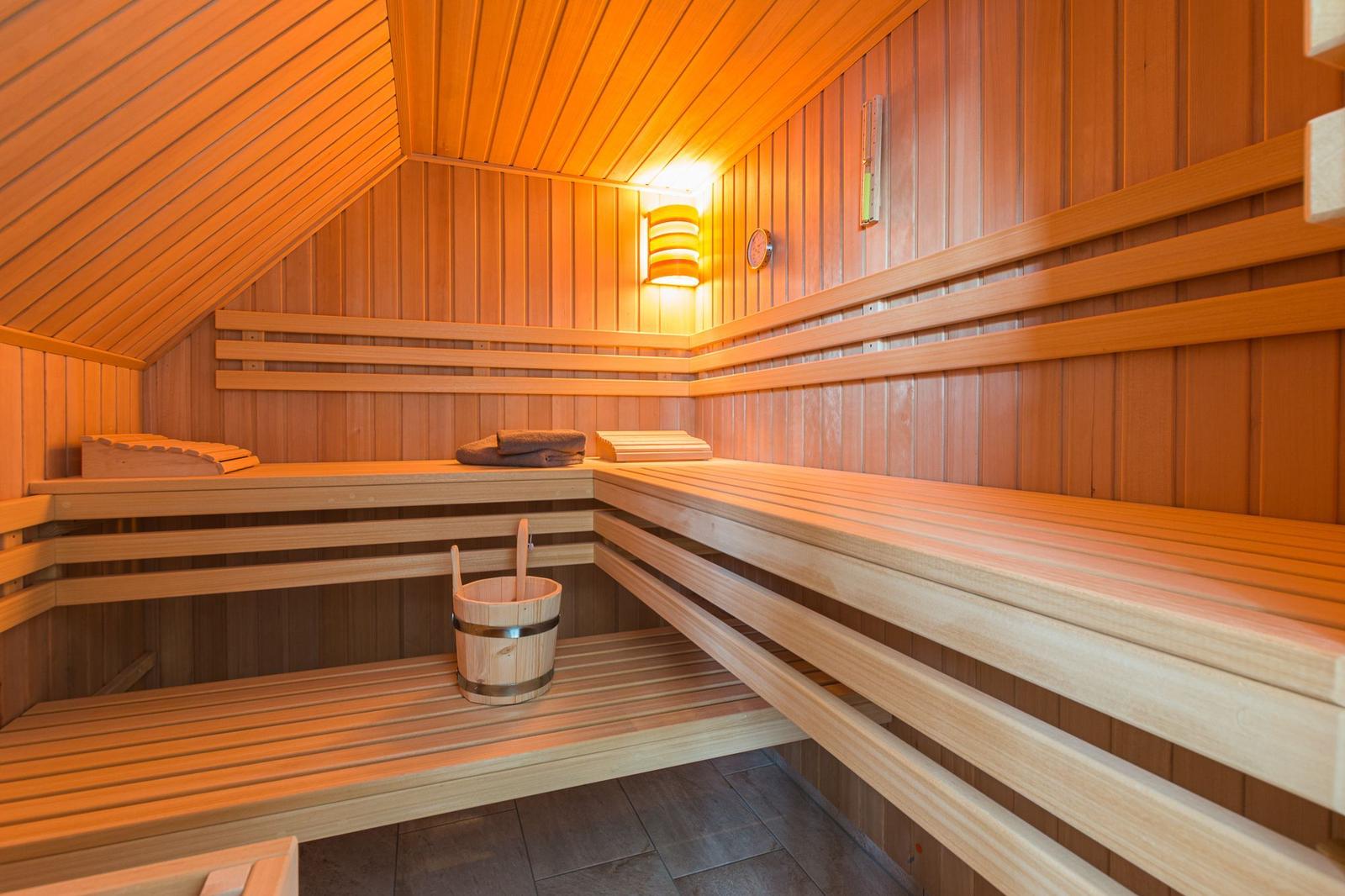 Sauna mit Holzbanken, Eimer und Handtuch