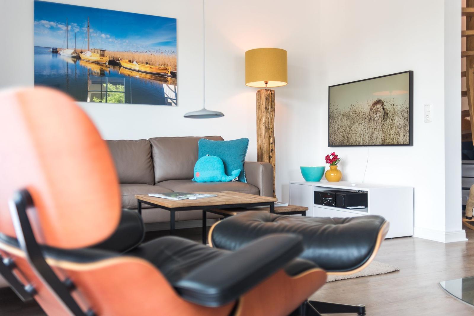 Ein Wohnzimmer mit Sofa, Couchtisch und Fernseher an der Wand.