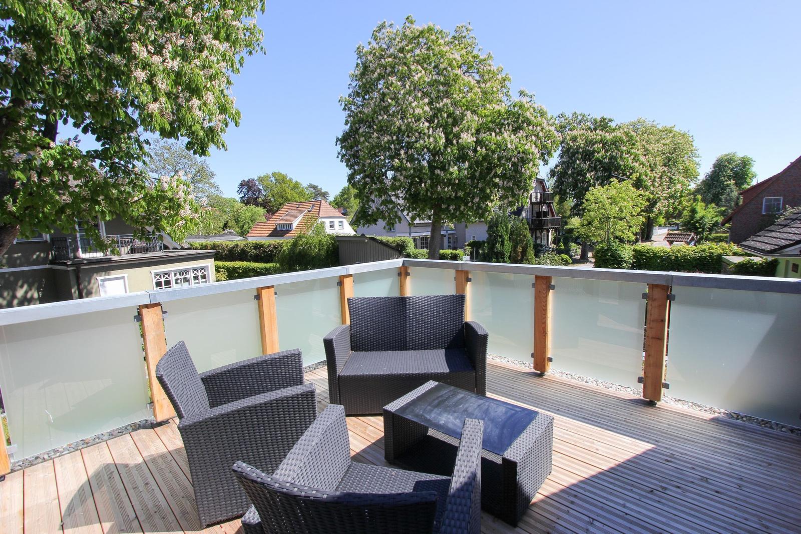 Terrasse mit Gartenmöbeln und Blick auf begrünte Umgebung.