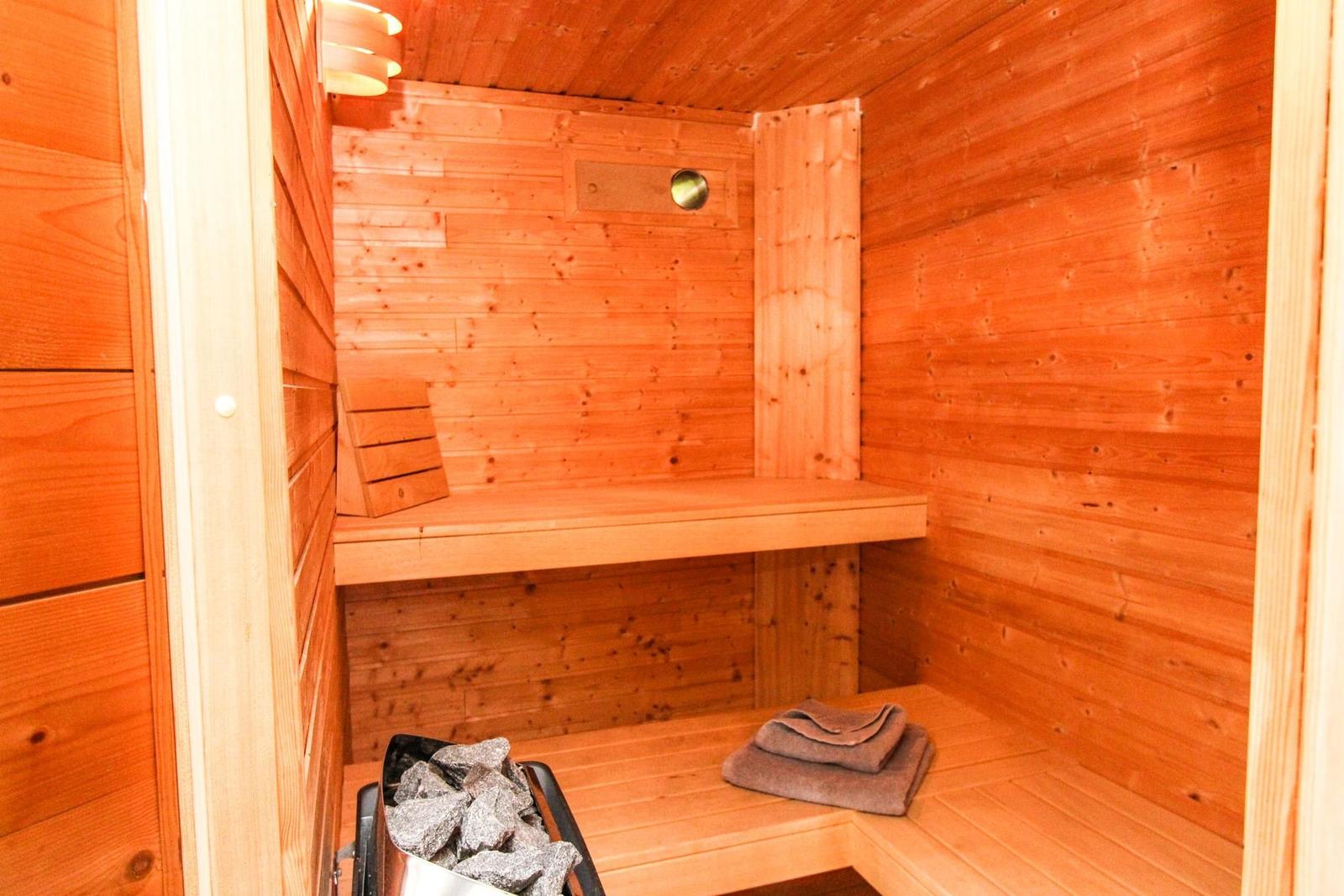 Sauna mit Holzwand, Sitzbank und Handtuch