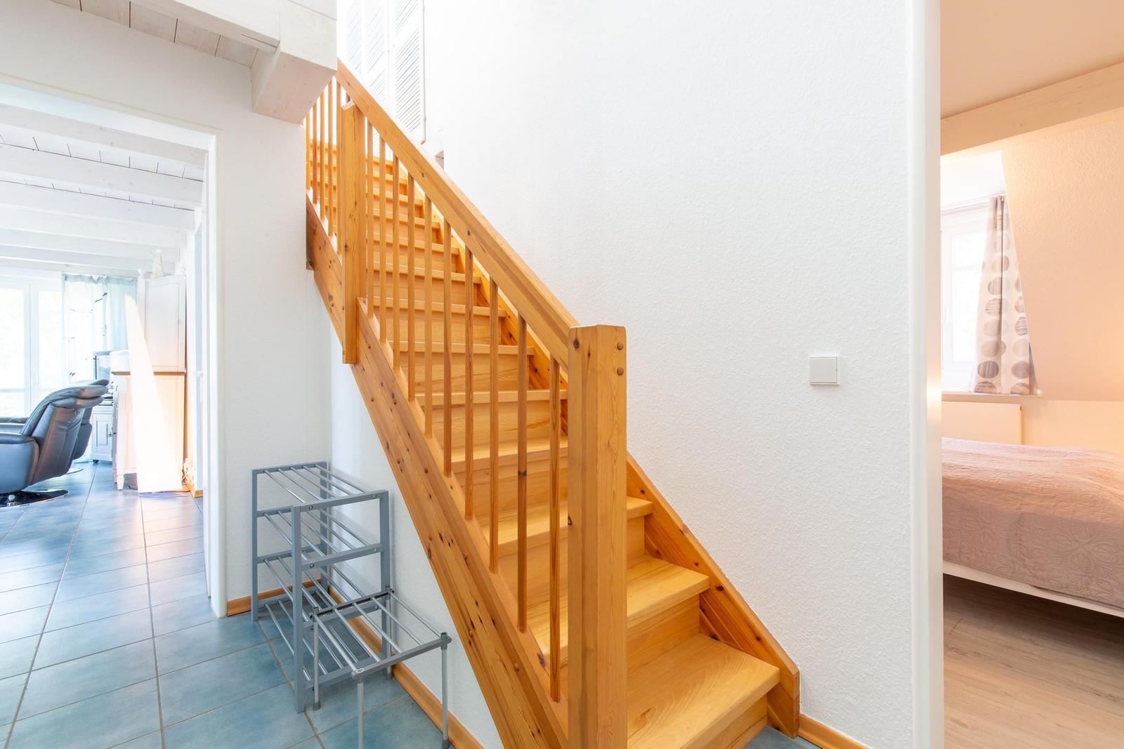Holztreppenhaus mit Blick in Wohn- und Schlafzimmer
