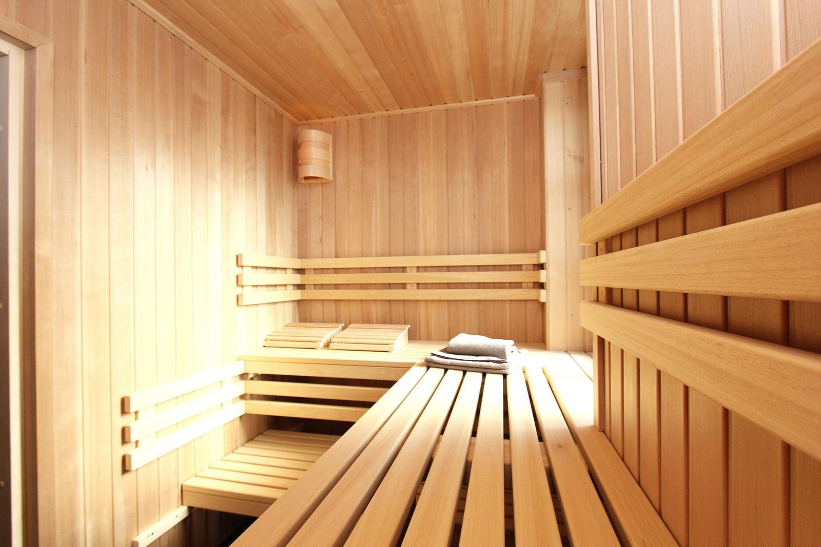 Sauna mit Holzbänken und einer Deckenleuchte.