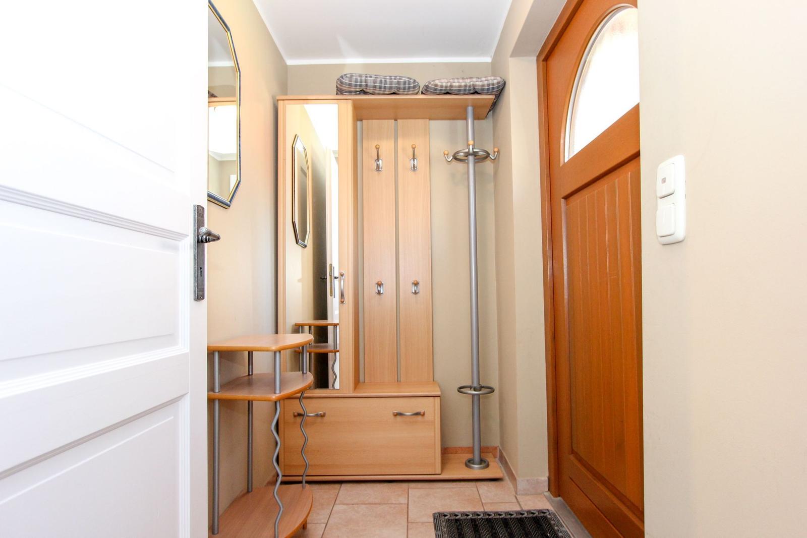 Eingangsbereich mit Garderobe, Spiegel und Haken für Jacken.