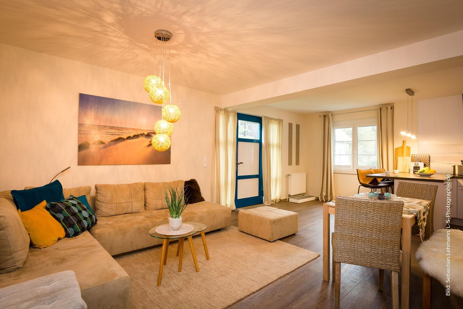 Wohn- und Essbereich mit Sofa, Esstisch und Wandbild.