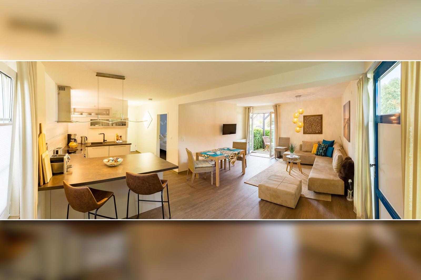 Wohnküche mit Essbereich und Schlafzimmer im Hintergrund.