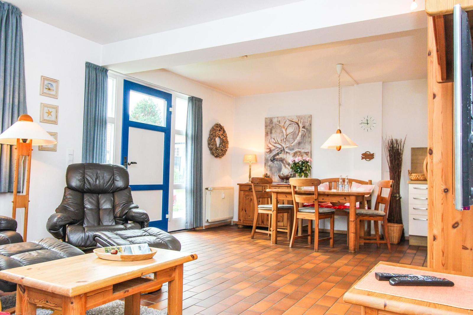 Wohn- und Essbereich mit Holzmöbeln, Sitzgelegenheiten und Fenster zur Außenseite.