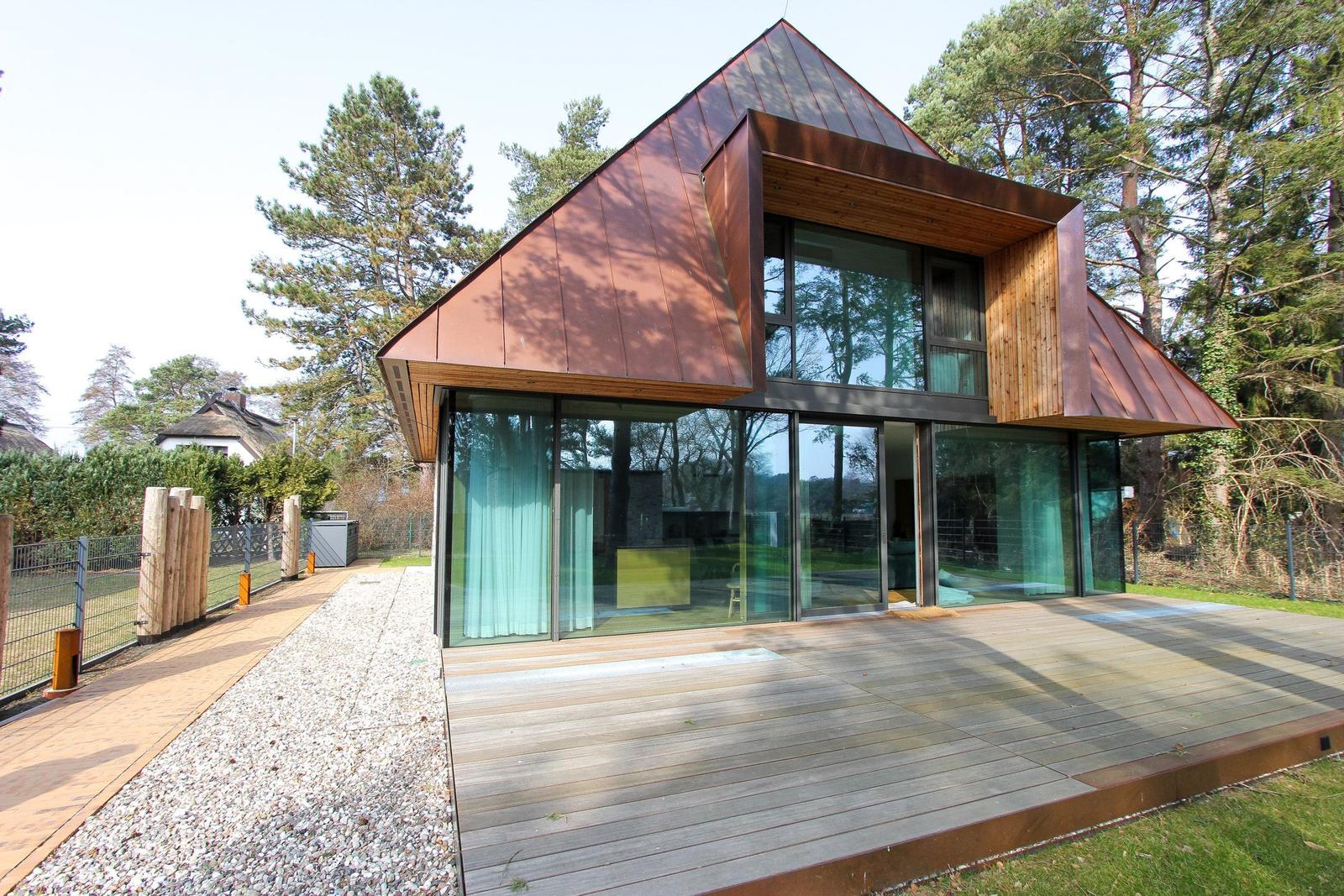 Moderne Holzhütte mit großem Glasbereich und Terrasse im Wald