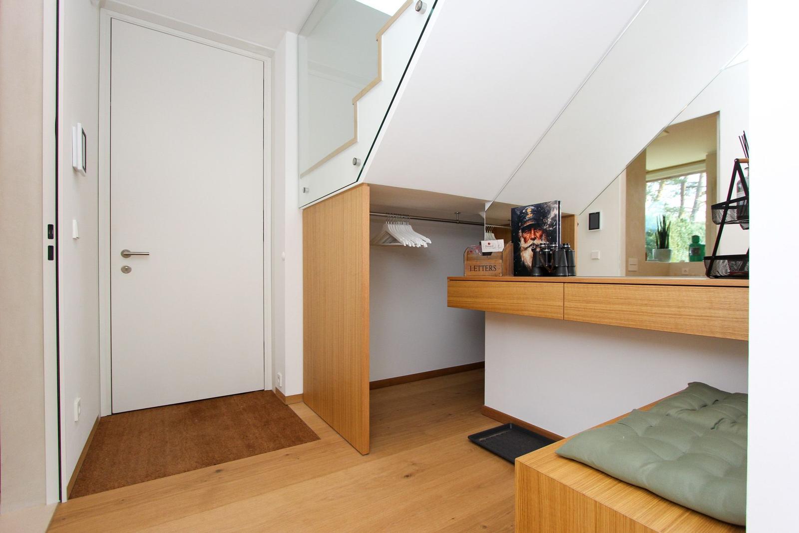 Schlafzimmer mit Dachschräge, Kleiderschrank und Schreibtisch mit Spiegel.