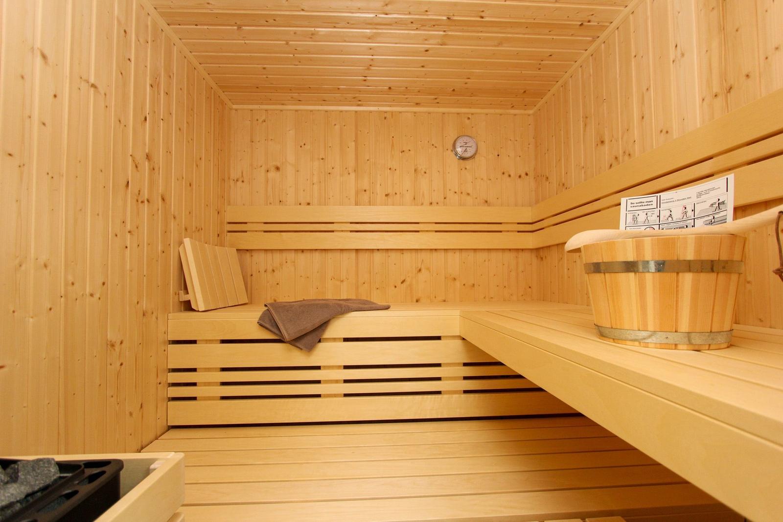 Sauna mit Holzbank, Eimer und Handtuch