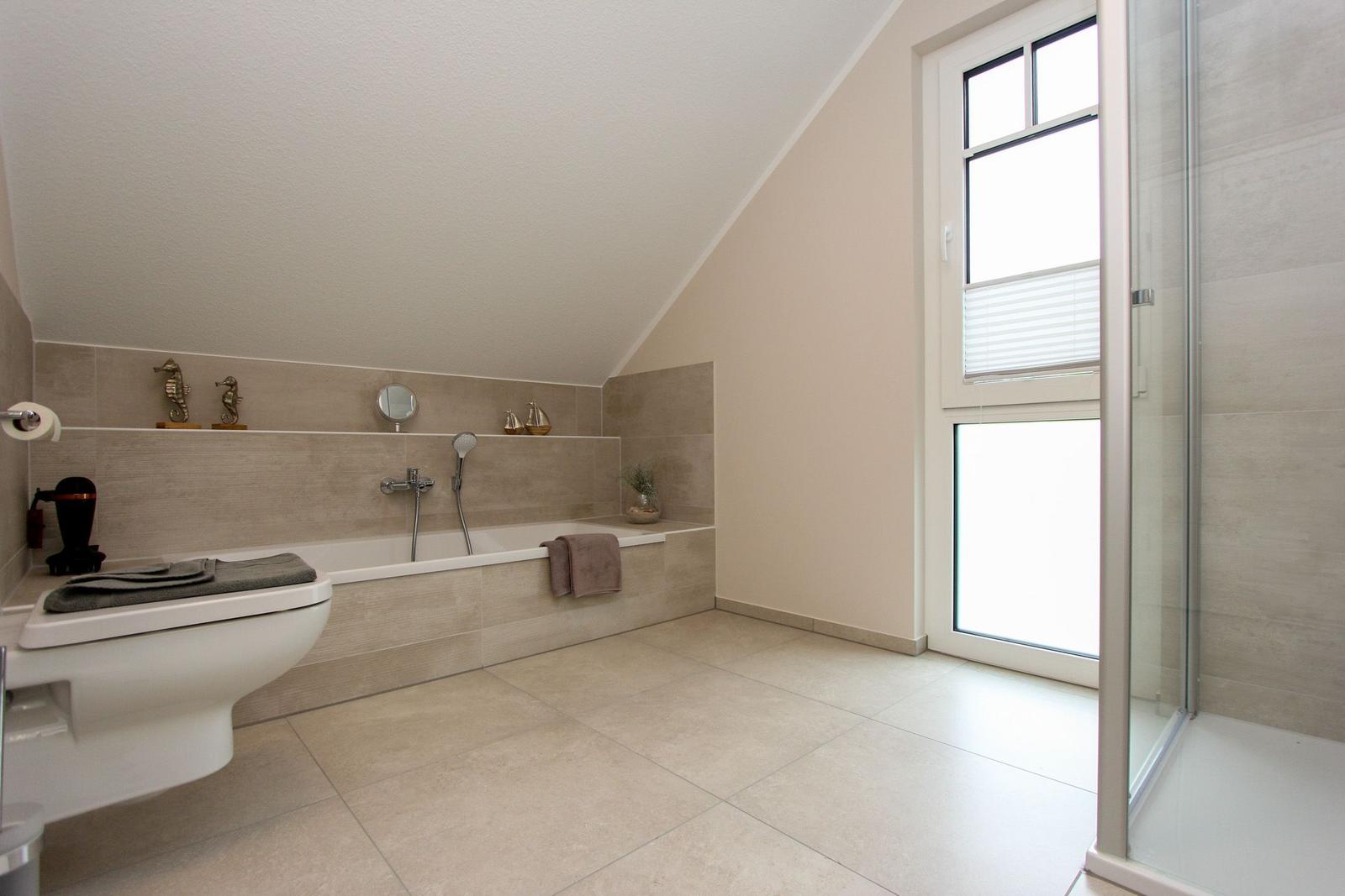 Badezimmer mit Badewanne, Dusche und Fenster. Wand- und Bodenfliesen in neutralen Tönen.