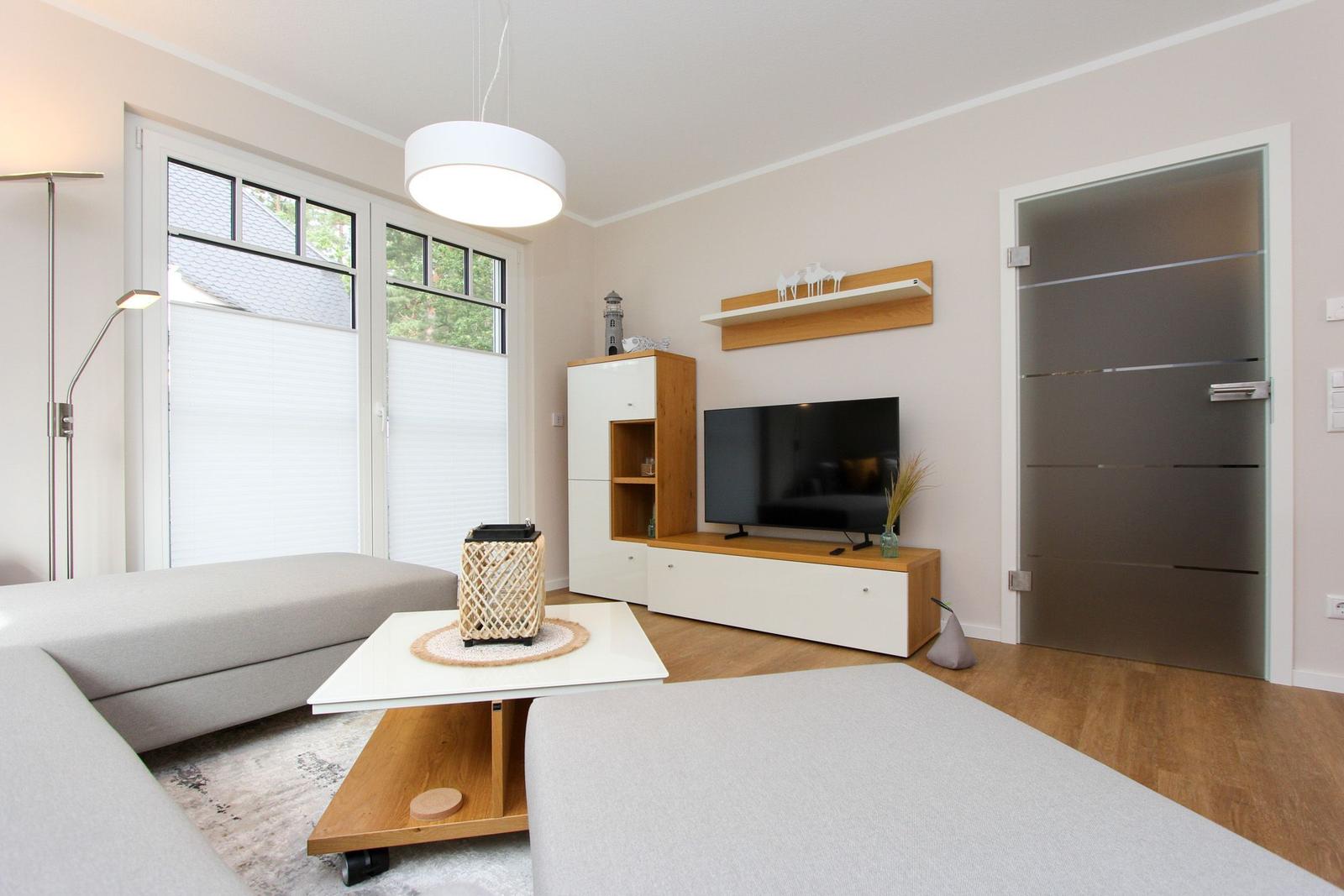 Wohnzimmer mit Sofa, TV und Fenster