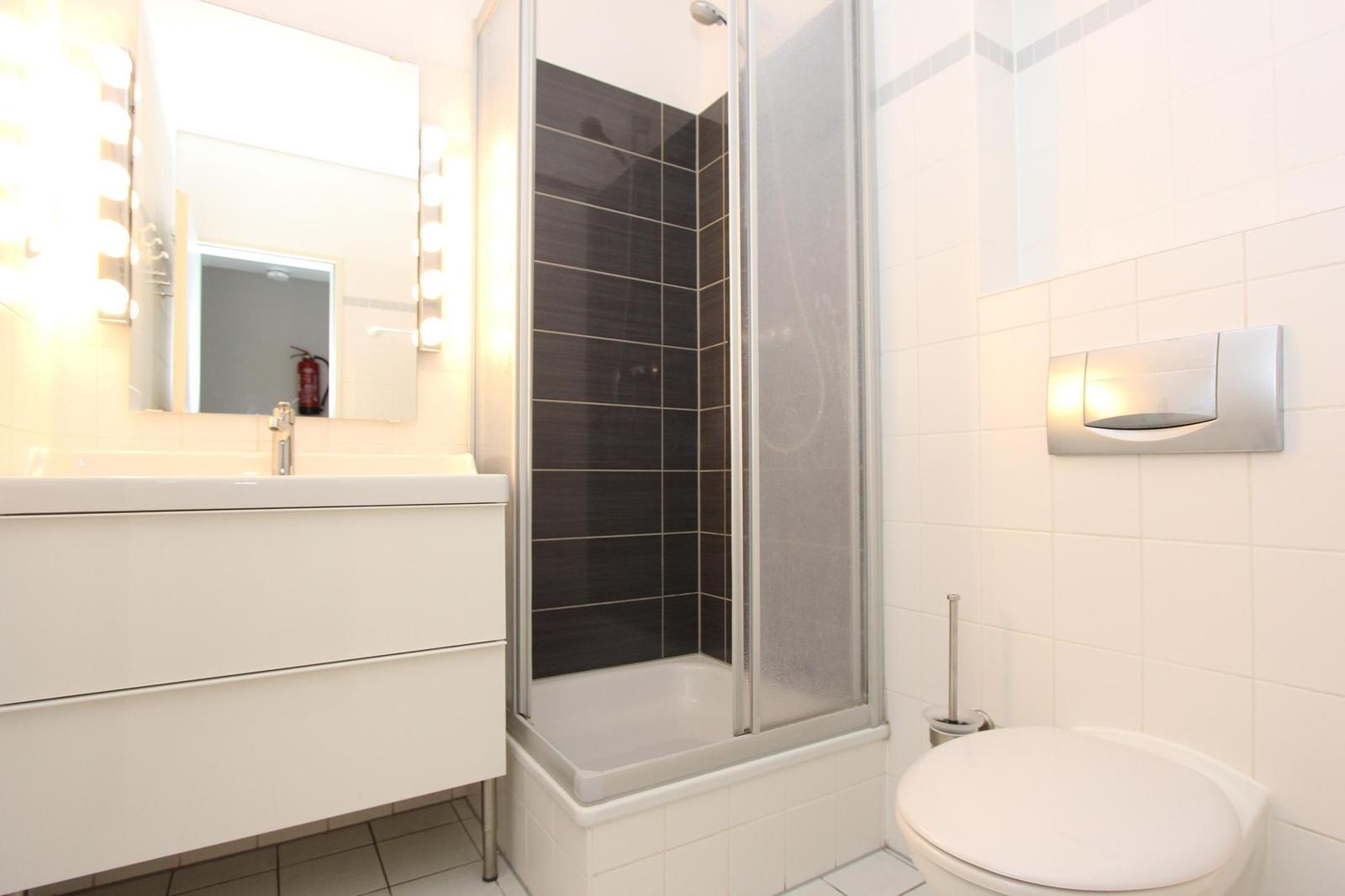 Badezimmer mit Dusche, Waschbecken und Toilette.