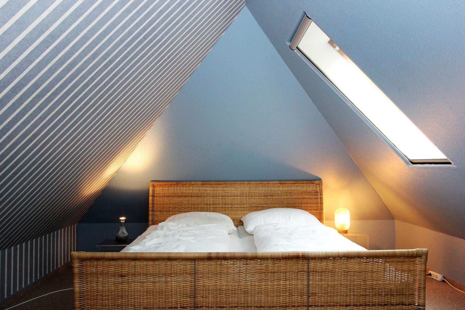 Schlafzimmer mit Dachschrägen, Dachfenster und Rattanbett