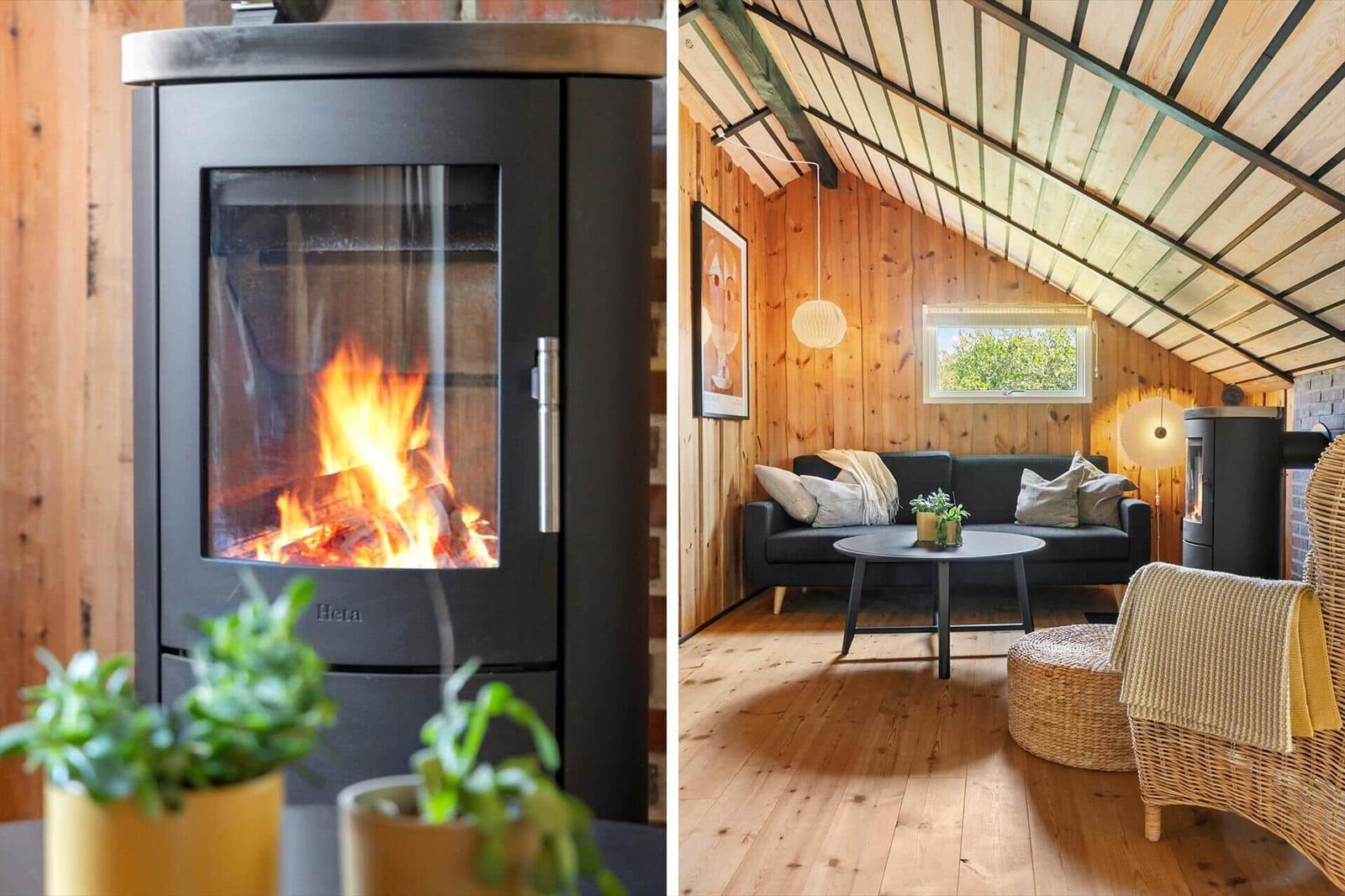 Wohnzimmer mit Kamin, Sofa und Holzboden unter schrägem Dach.
