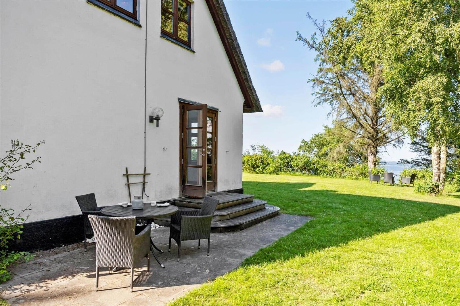 Haus mit Terrasse, Garten und Blick auf Wasser